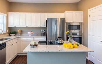 A kitchen with a marble countertop and a refrigerator.